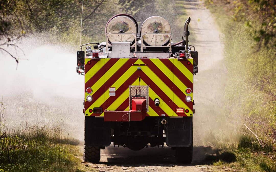 Fire truck travelling along a dirt access track during bushfire management operations.