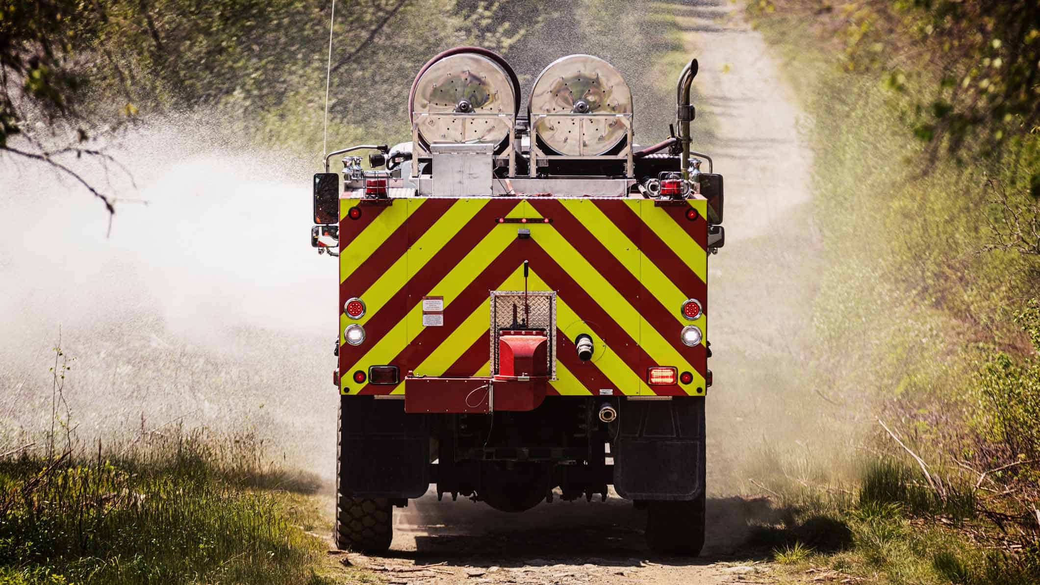 Fire truck travelling along a dirt access track during bushfire management operations.