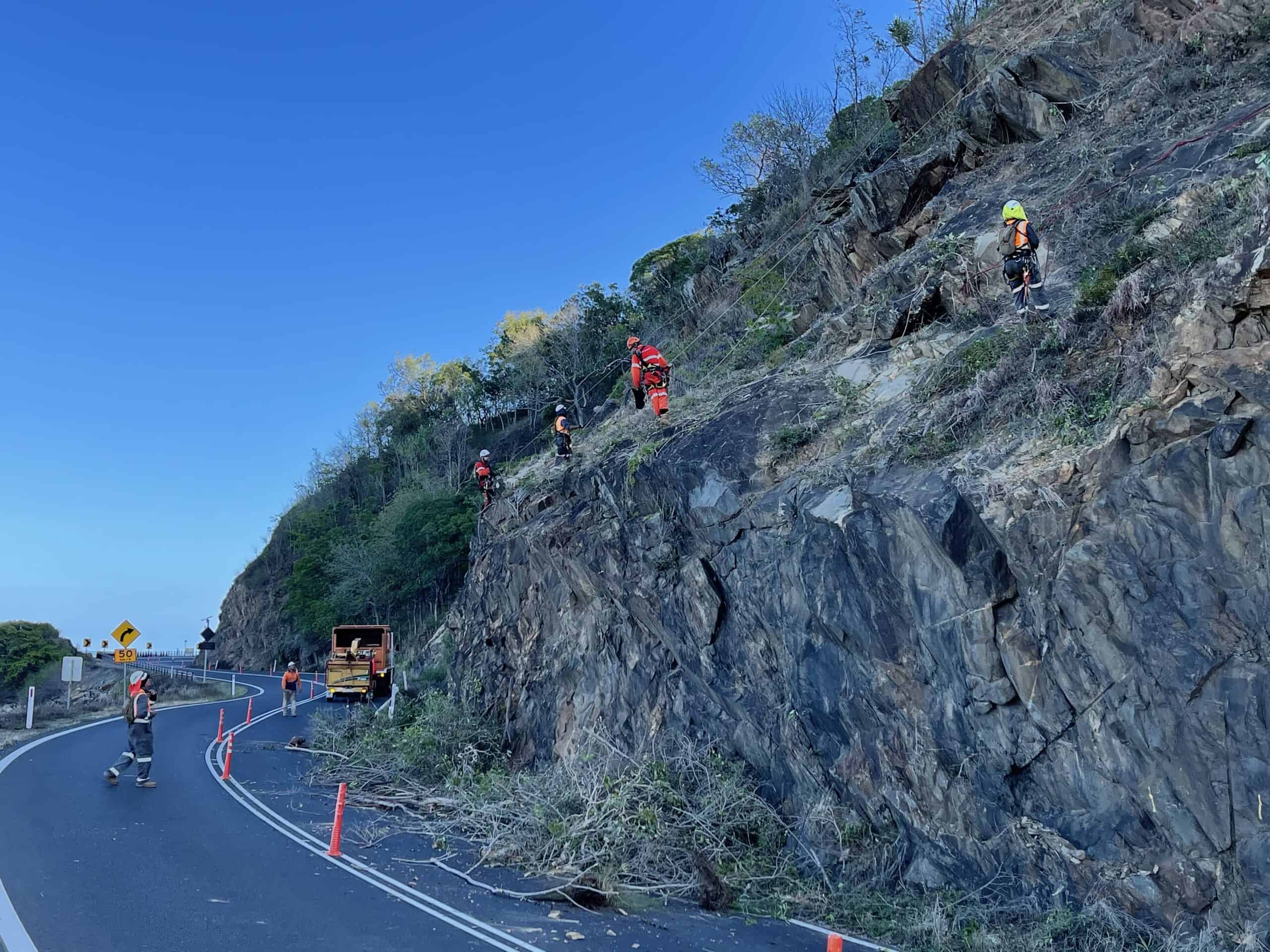 Workers undertaking slope remediation works beside the Captain Cook Highway near Port Douglas.