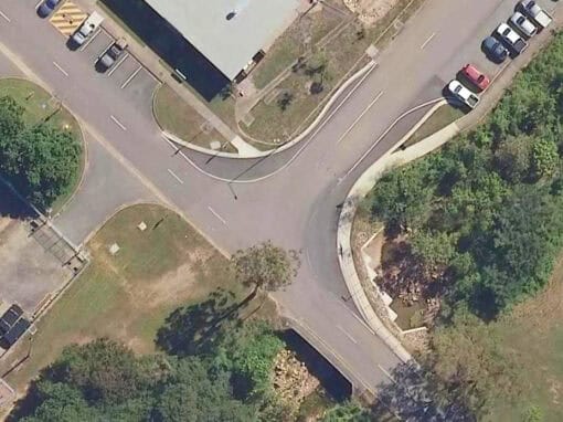 Aerial view of a road intersection within Lavarack Barracks showing the existing road layout and surrounding infrastructure.