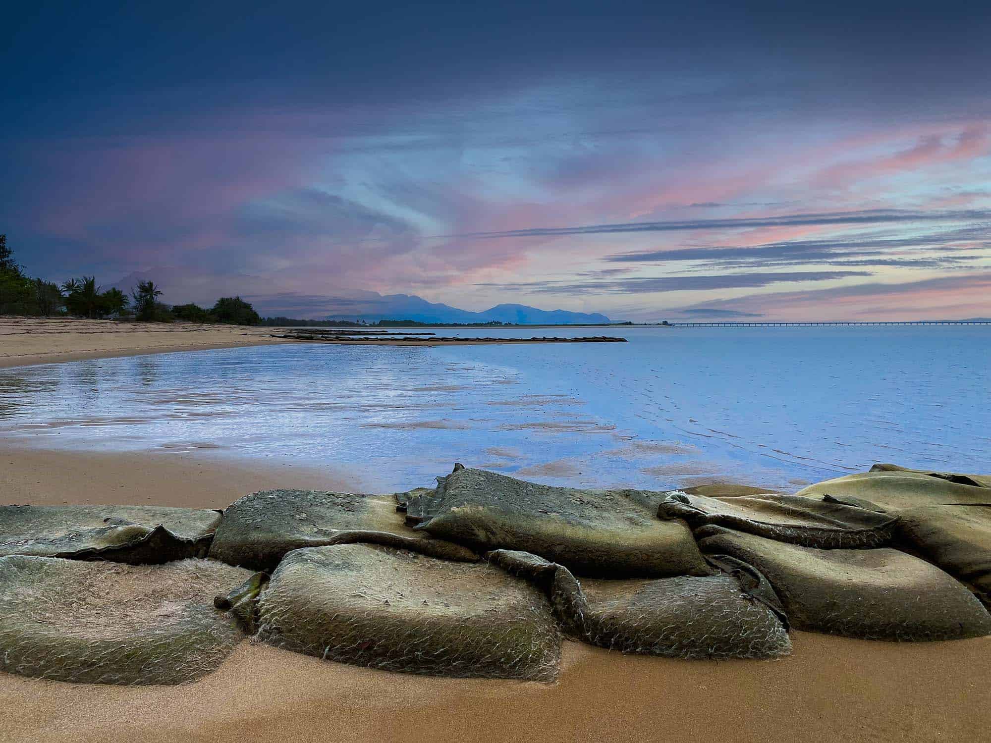 Original coastal groynes at the Lucinda shoreline during sunset.