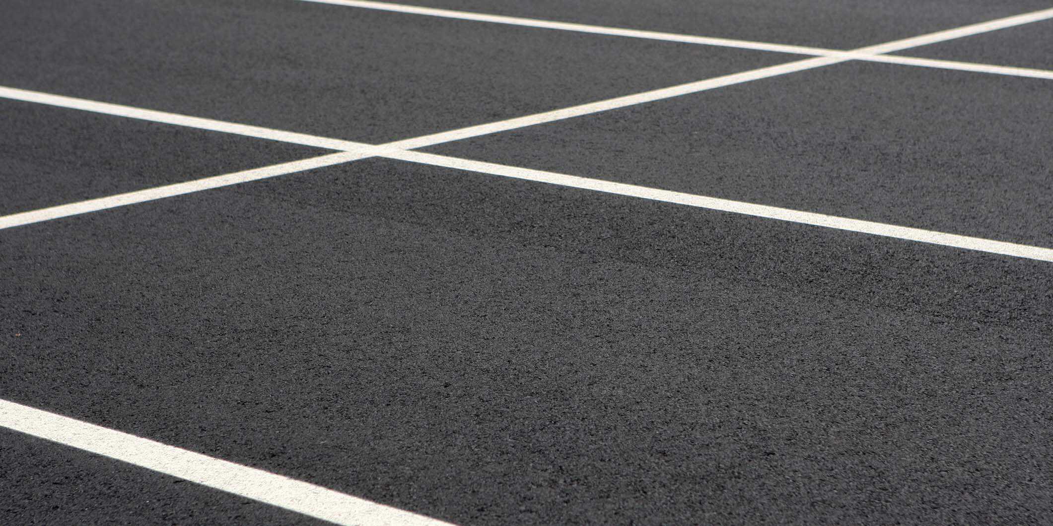 Newly completed asphalt pavement with line marking at a car park.