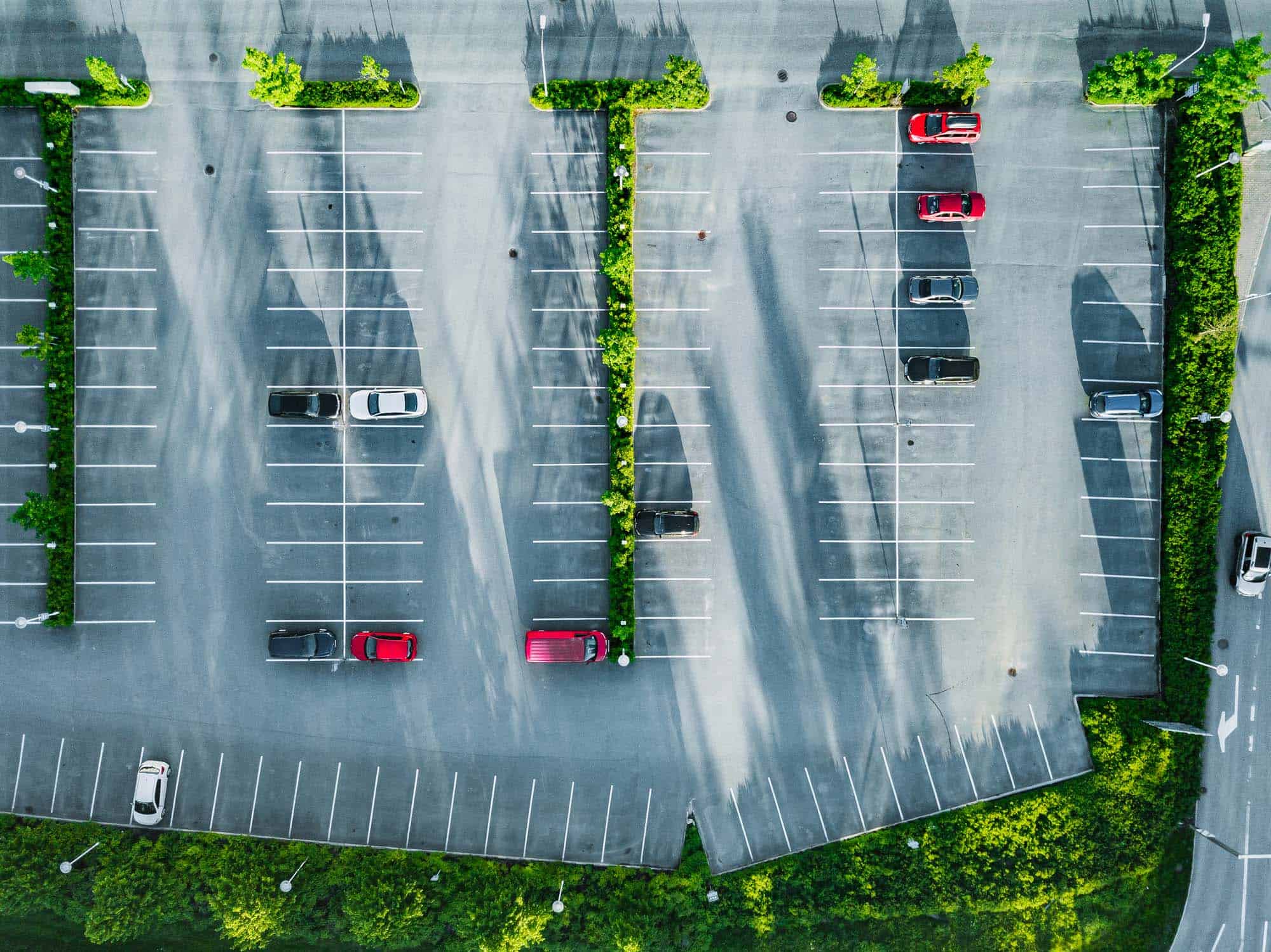 Aerial view of a car park with marked parking bays and landscaped areas.
